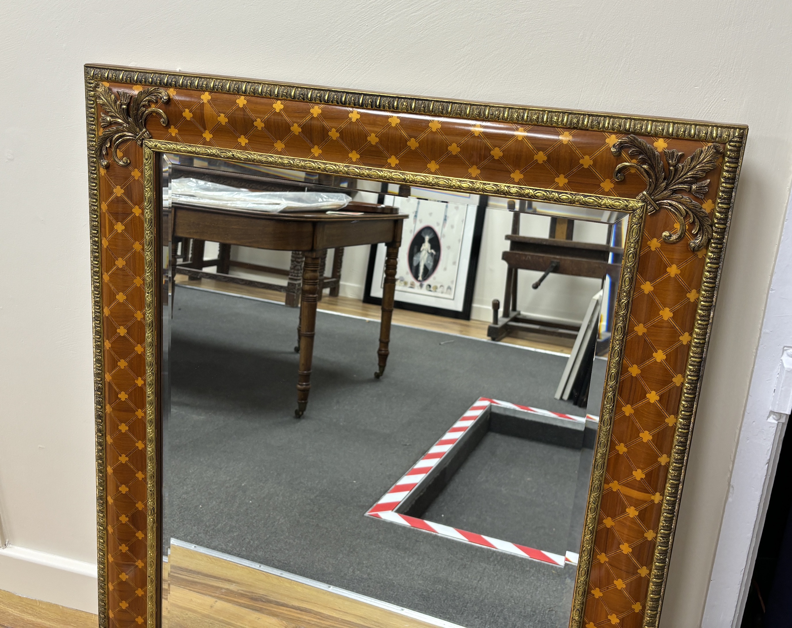 A bevelled wall mirror, the inlaid frame with trellis pattern and gilt metal mounts (purchased from Harrods), width 99cm, height 80cm